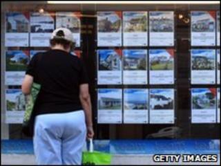 Woman looking in an estate agent's window