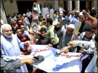 Egyptians worshippers symbolically hit an Israeli flag with their shoes