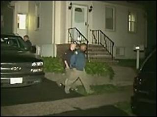 Law enforcement agents outside one of the arrested men's homes