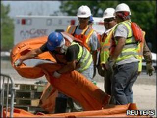 Workers putting down booms in Louisiana to try to halt the oil spill