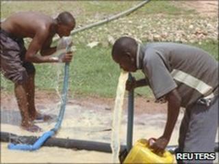 Men drinking potentially contaminated water in affected village