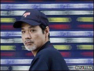 Man walking past electronic stock board in Tokyo