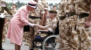 The Queen presents a medal to Fusilier Shaun Stocker at Chester Racecourse