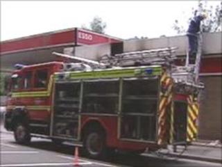 A firefighter dampens down at the petrol station in Mountain Ash