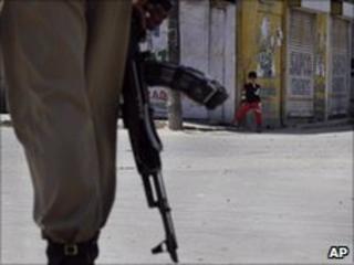 A paramilitary soldier patrols a deserted street in Srinagar on Sunday, June 13, 2010