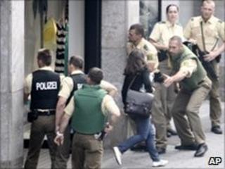 Police officers try to protect pedestrians close to the shop