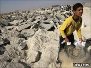 A Palestinian labourer collects gravel at abandoned airport in Rafah