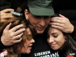 Former hostage Gen Luis Mendieta embracing wife and daughter