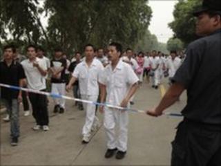 A policeman stands by a cordon tape as workers walk out of a Honda Motor factory on strike in Zhongshan, Guangdong, China, on 11 June, 2010.