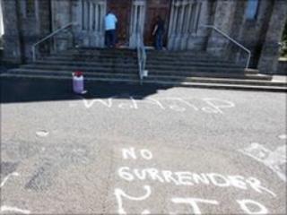 Members of the congregation attempt to wash away the graffiti