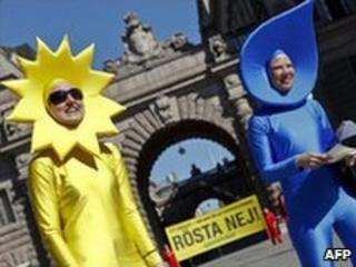 Greenpeace activists dressed up as water and sun elements demonstrate outside the Swedish parliament building