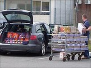 A shopper loads his car with alcohol