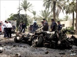 Police inspect one of the vehicles which exploded in Baghdad (20 June 2010)