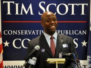 Tim Scott standing in front of microphones