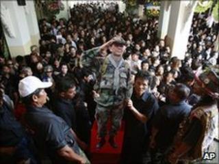Supporters hold up a cutout of Maj Gen Khattiya Sawasdiphol during his cremation ceremony