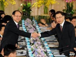 Taiwan delegation head Kao Koong-lian (R) shakes hands with Chinese counterpart Zheng Lizhong at the talks on 24 June
