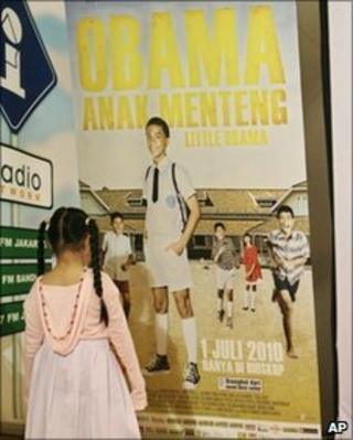 A girl looks at a poster for the film Obama Anak Menteng before its premiere in Jakarta