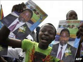 A man carries pictures of Congolese president Joseph Kabila during independence day celebrations