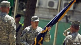 Gen David Petraeus holds a flag during the assumption-of-command ceremony in Kabul on 4/7/2010