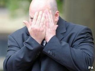 Paul Barrett hides his face as he leaves court