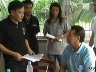 Thai police confront Mikhail Pletnev (in light blue shirt)