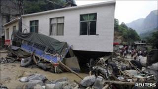 Damaged vehicles and buildings in Xiaohe, Yunnan, on 14 July 2010