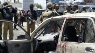 Pakistani soldiers and police officers at the site of the bombing in Mingora