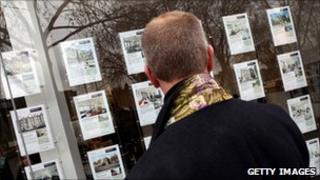 Man looking in an estate agent's window