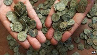 Сотрудник Британского музея показывает несколько монет