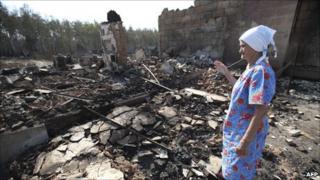 An old woman surveys her fire-ravaged home in Voronezh, central Russia, 1 August