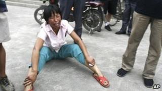 A woman cries after a tractor went on the rampage in Hebei province in China 1 August 2010