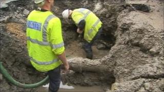 Workmen repairing the pipe