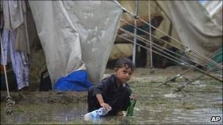 A child plays in the rain, Risalpur, Pakistan, 08/08