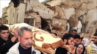 People carry a stretcher next to the collapsed minaret in Meknes (20 February 2010)