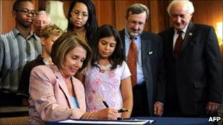 US Speaker of the House Nancy Pelosi signs the state aid bill, surrounded by school children and members of Congress, August 10, 2010.