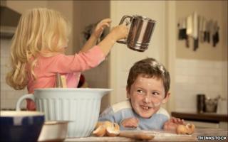 Sister tips flour over brother's head