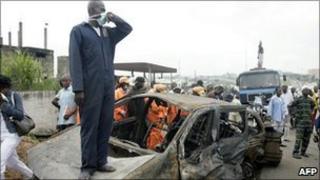 A rescue worker stands on one of the burnt vehicles at the scene of the accident on Lagos-Ibadan highway on 16 August 2010