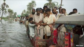 Villagers travel on tractors through floodwater in Punjab province, Pakistan (16 August 2010)