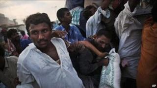 Pakistanis grab a bag of food aid on the road outside of Sukkur, in Sindh province, Pakistan on 17 August, 2010