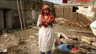 A woman cries in her flood-ruined home in Pir Sabaq in north-west Pakistan on 18 August, 2010