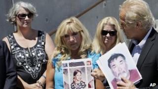 Teresa Ronson (c) holds up a picture of her aged 11. Attorney Jeff Anderson (r) holds a photo of Stephen Kiesle