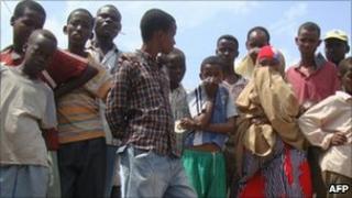 Crowd look at the dead body of alleged Islamist militant who died in the blast