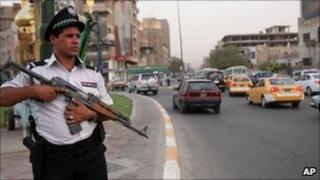 An Iraqi traffic policeman holds an AK-47 in central Baghdad, Iraq, Aug 2010