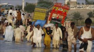 People walk through flood water in Baseera, Punjab province, Pakistan (23 August 2010)