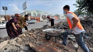 Residents rebuild a house in Osh on 21 August 2010