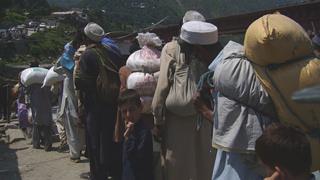 Local people queue to cross the bridge