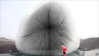 A visitor stands next to the UK Pavilion at the Shanghai World Expo