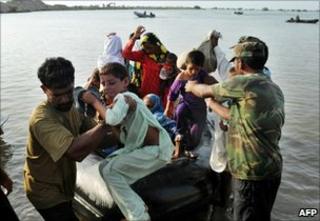 Pakistani soldiers help flood affected villagers from boats in Khairpur Nathan Shah in southern Sindh province