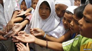 A man gives money to children in Taguig, the Philippines. Photo: August 2010