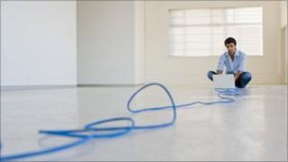 Man at computer at end of cable (Thinkstock)